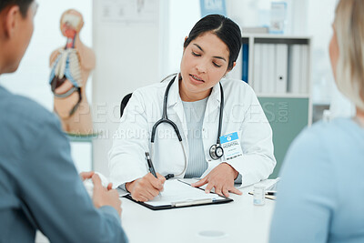 Buy stock photo Shot of a couple consulting with a doctor at a clinic