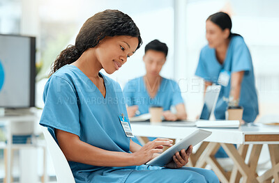 Buy stock photo Shot of a young female doctor using a digital tablet at a hospital