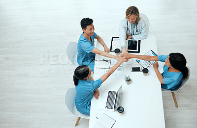 Buy stock photo High angle shot of a group of doctors stacking their hands  while in a meeting at a hospital