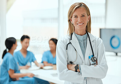 Buy stock photo Shot of a mature female doctor standing with her arms crossed at a hospital