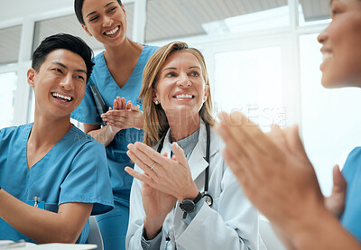Buy stock photo Shot of a group of doctors clapping hands in a meeting at work