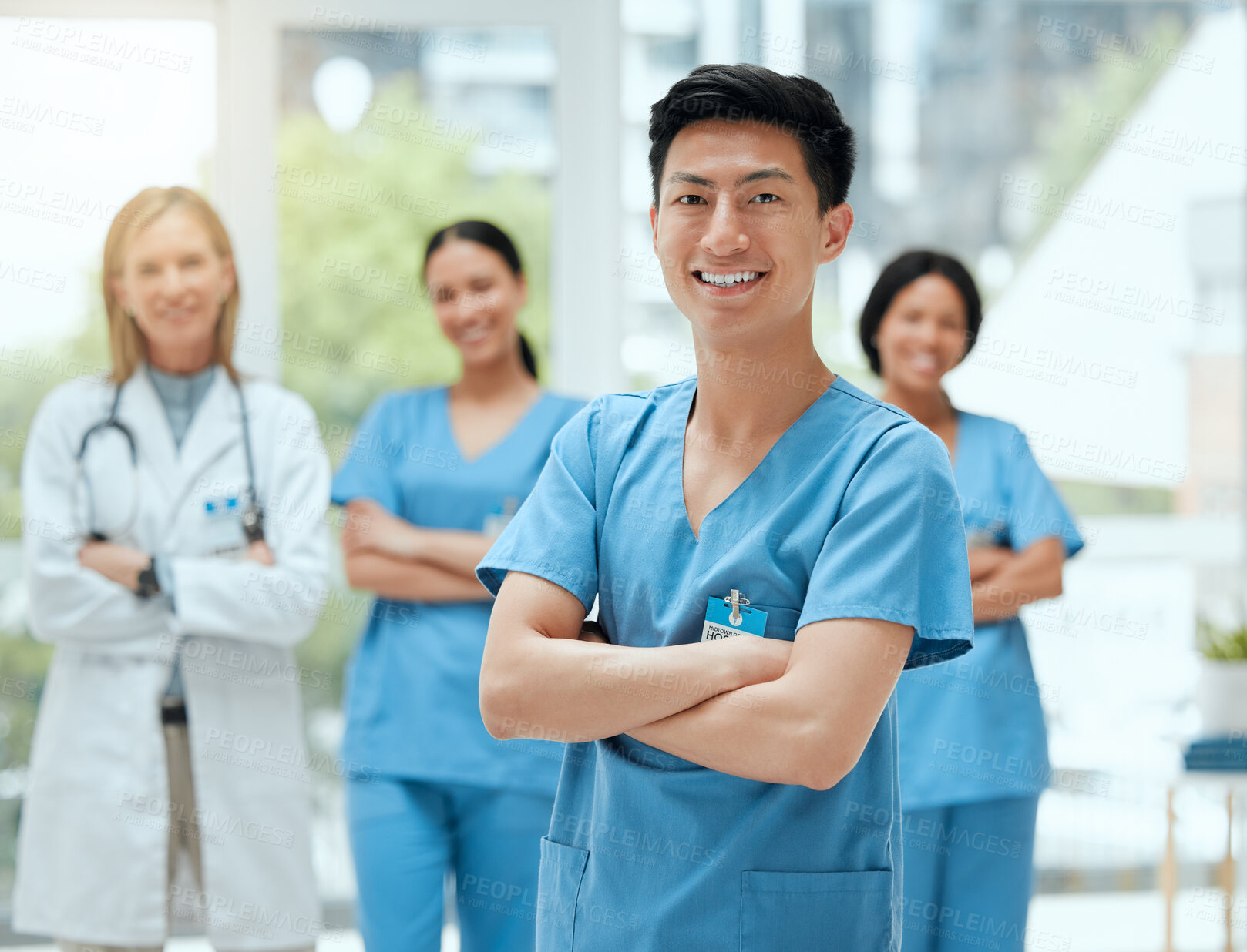 Buy stock photo Portrait, medical and an asian man nurse arms crossed, standing with his team in a hospital for healthcare. Leadership, medicine and teamwork with a male health professional in a clinic for treatment