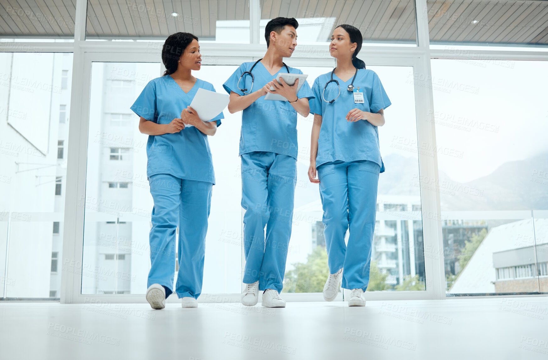 Buy stock photo Teamwork, discussion or medical students walking or planning a surgery strategy in collaboration. Internship, doctors or young surgeons with tablet talking, working or speaking of hospital healthcare