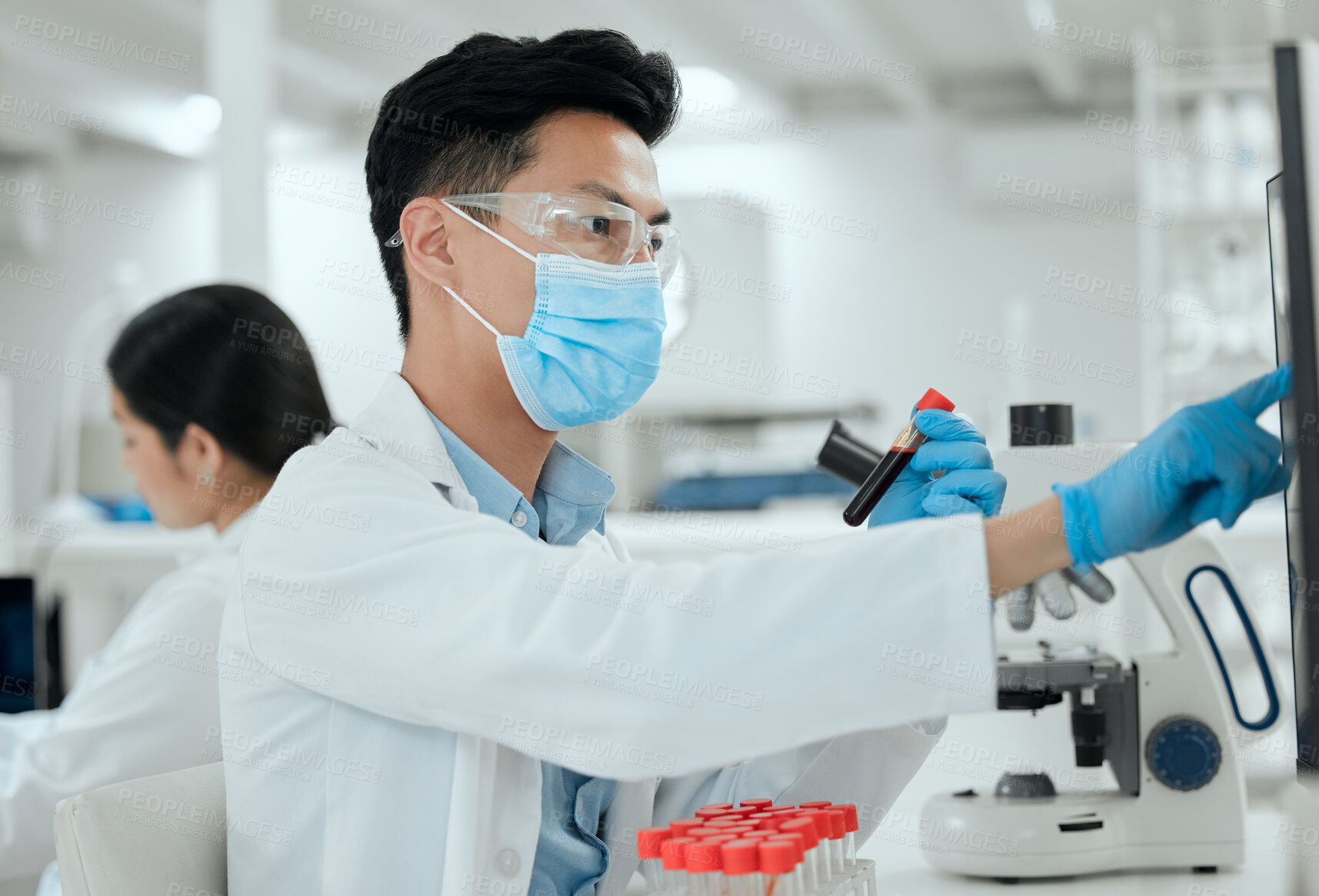 Buy stock photo Shot of a young male scientist working in a lab
