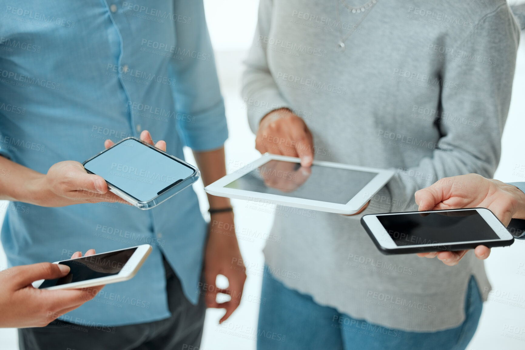 Buy stock photo Cropped shot of a group of unrecignizable businesspeople using their smart phones