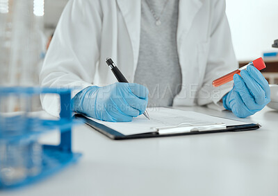 Buy stock photo Shot of a scientist holding a sample while making notes