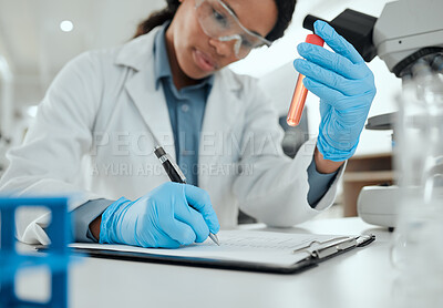 Buy stock photo Shot of a young woman reviewing a test tube sample in the lab