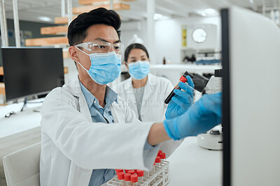 Buy stock photo Shot of a young scientist reviewing a sample in the lab