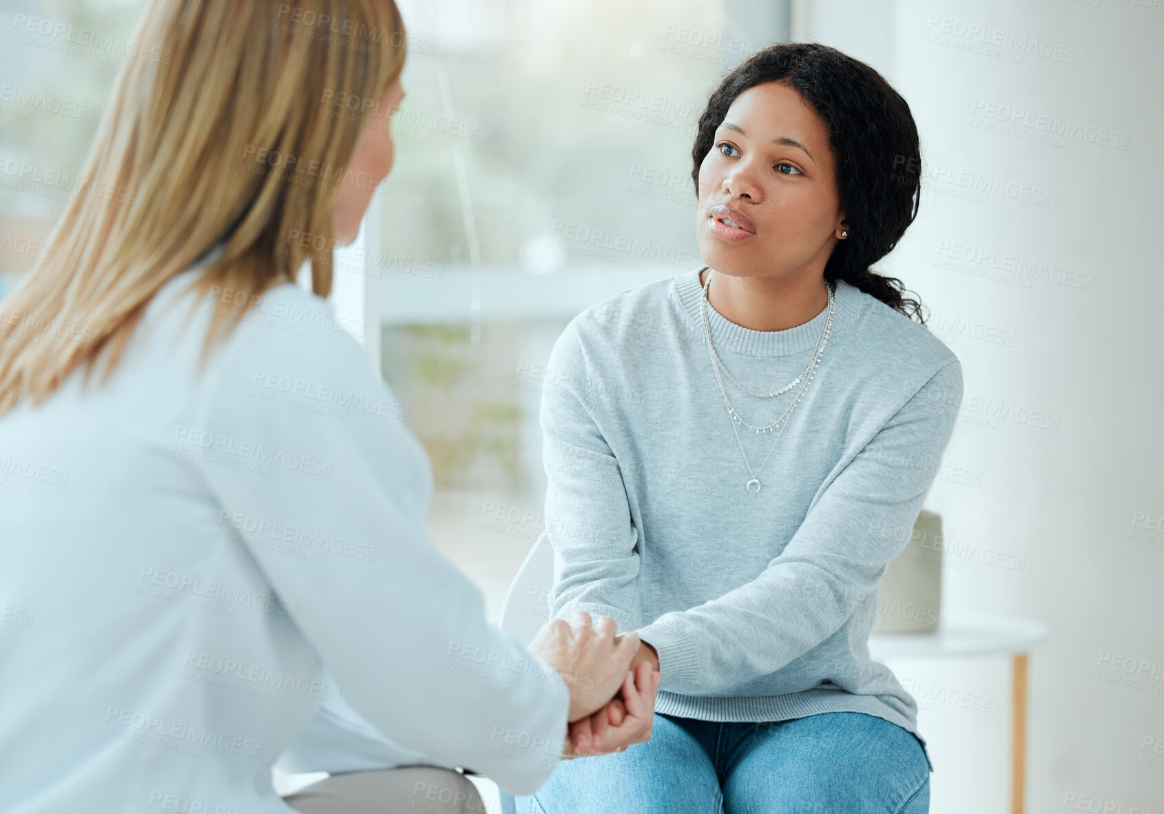 Buy stock photo Women, doctor and patient with holding hands in hospital for support, trust and care. People, medical professional and comfort with feedback or discussion and advice on diagnosis in consultation