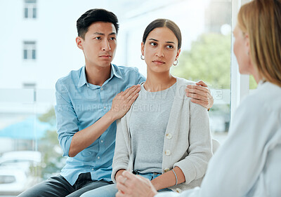 Buy stock photo Shot of a mature doctor comforting a young couple while delivering some bad news at work