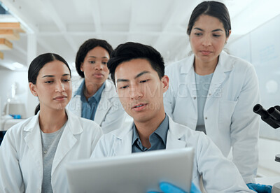 Buy stock photo Shot of a team of scientists using a digital tablet in their lab