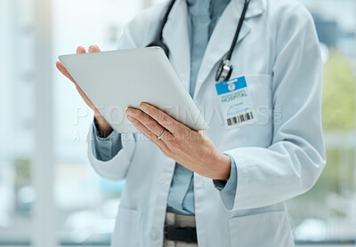 Buy stock photo Shot of an unrecognizable doctor using a digital tablet at work