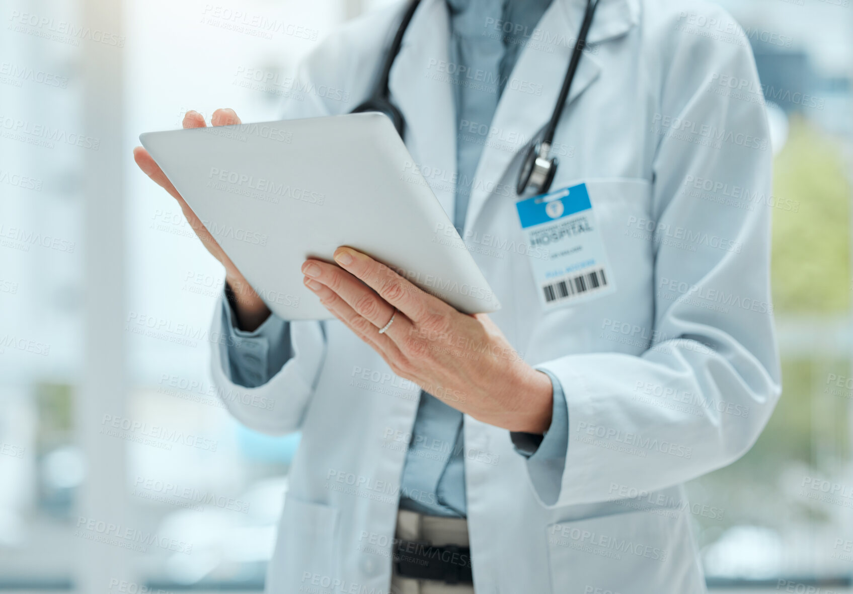 Buy stock photo Shot of an unrecognizable doctor using a digital tablet at work