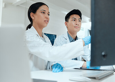 Buy stock photo Shot of two scientists working together on their PC in the lab