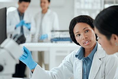 Buy stock photo Shot of two scientists helping one another in the lab