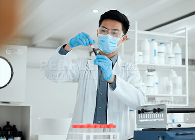 Buy stock photo Shot of a young male scientist filling a test tube