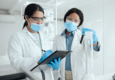 Buy stock photo Shot of two female scientists reviewing a sample together while making notes