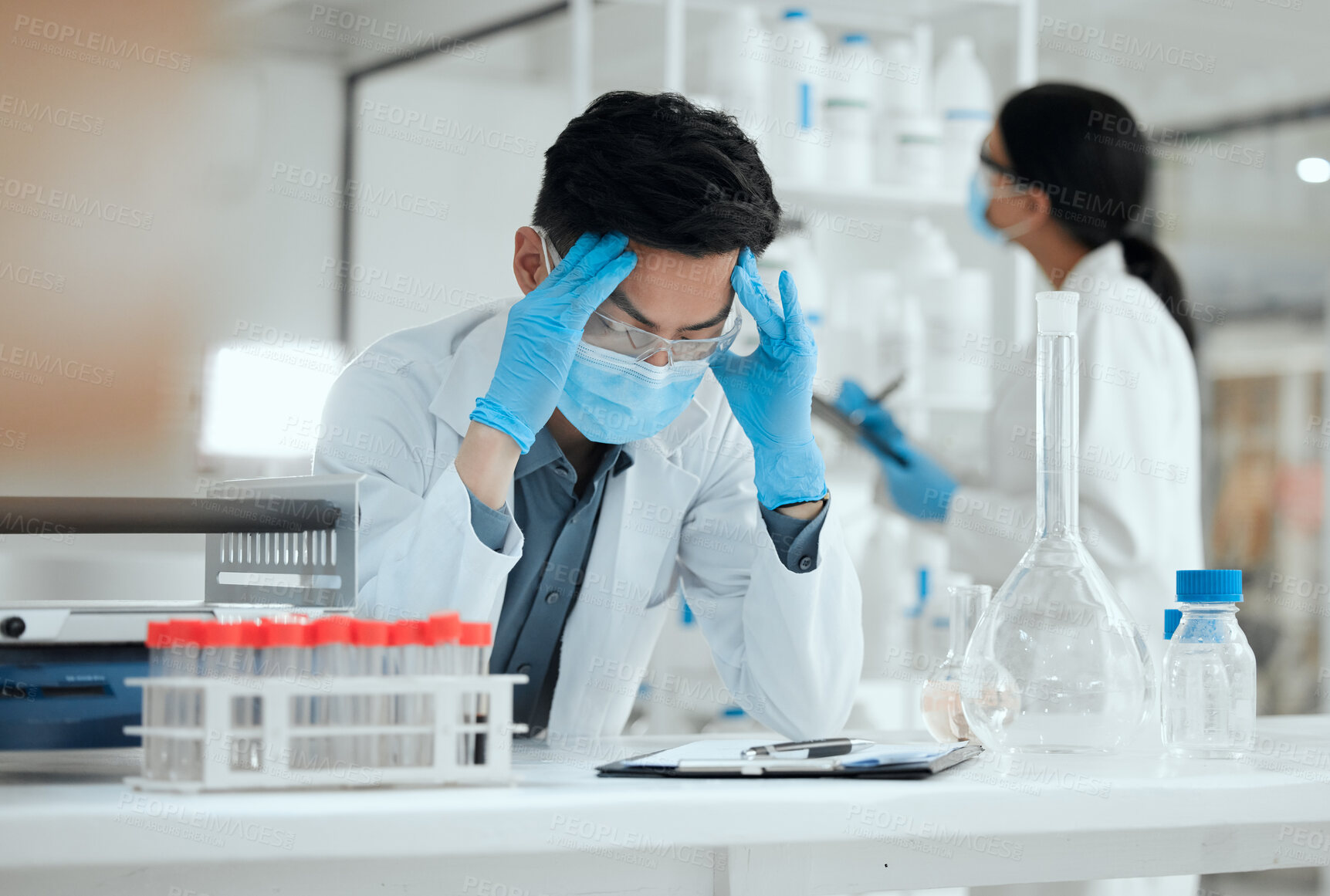 Buy stock photo Shot of a young scientist looking stressed out with a headache