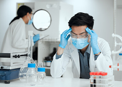 Buy stock photo Shot of a young scientist looking stressed out with a headache