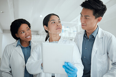 Buy stock photo Shot of a team of scientists using a digital tablet in their lab
