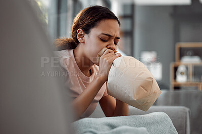Buy stock photo Shot of a young woman experiencing a panic attack while sitting on the sofa at home