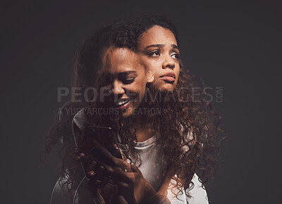 Buy stock photo Depression, mental health and woman in studio with stress, identity crisis or bipolar disorder. Horror, psycho and female person with trauma or anxiety browsing on a phone by a dark black background.