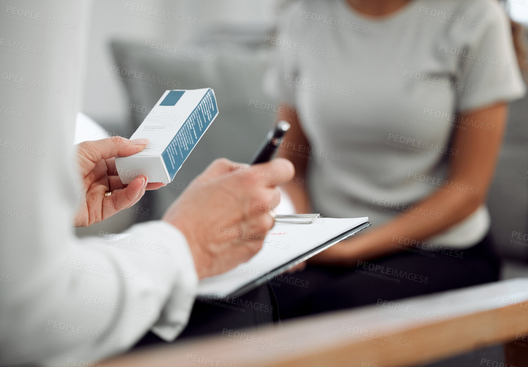 Buy stock photo Cropped shot of an unrecognisable psychologist sitting and prescribing anti-depressants to her patient during a consultation