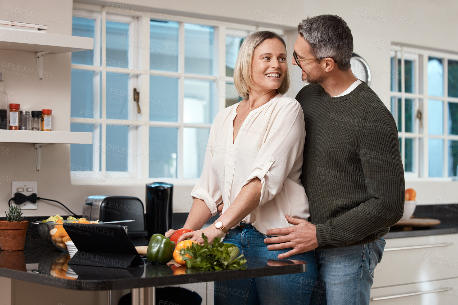 Buy stock photo Love, couple and cooking in kitchen with support for healthy online recipe, dinner preparation and bonding together. Home, mature people and affection with lunch meal, organic food and relationship