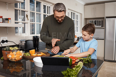 Buy stock photo Shot of a little boy cooking with his father at home