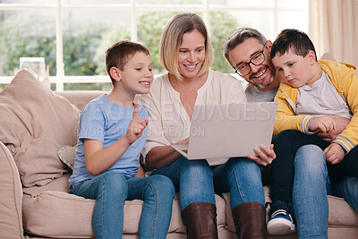 Buy stock photo Shot of a young family bonding while using a laptop on the sofa together at home