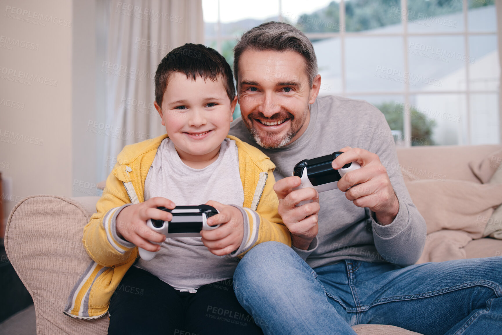 Buy stock photo Shot of a father and son playing video games while bonding on the couch at home