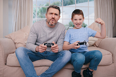 Buy stock photo Shot of a father and son playing video games while bonding on the couch at home