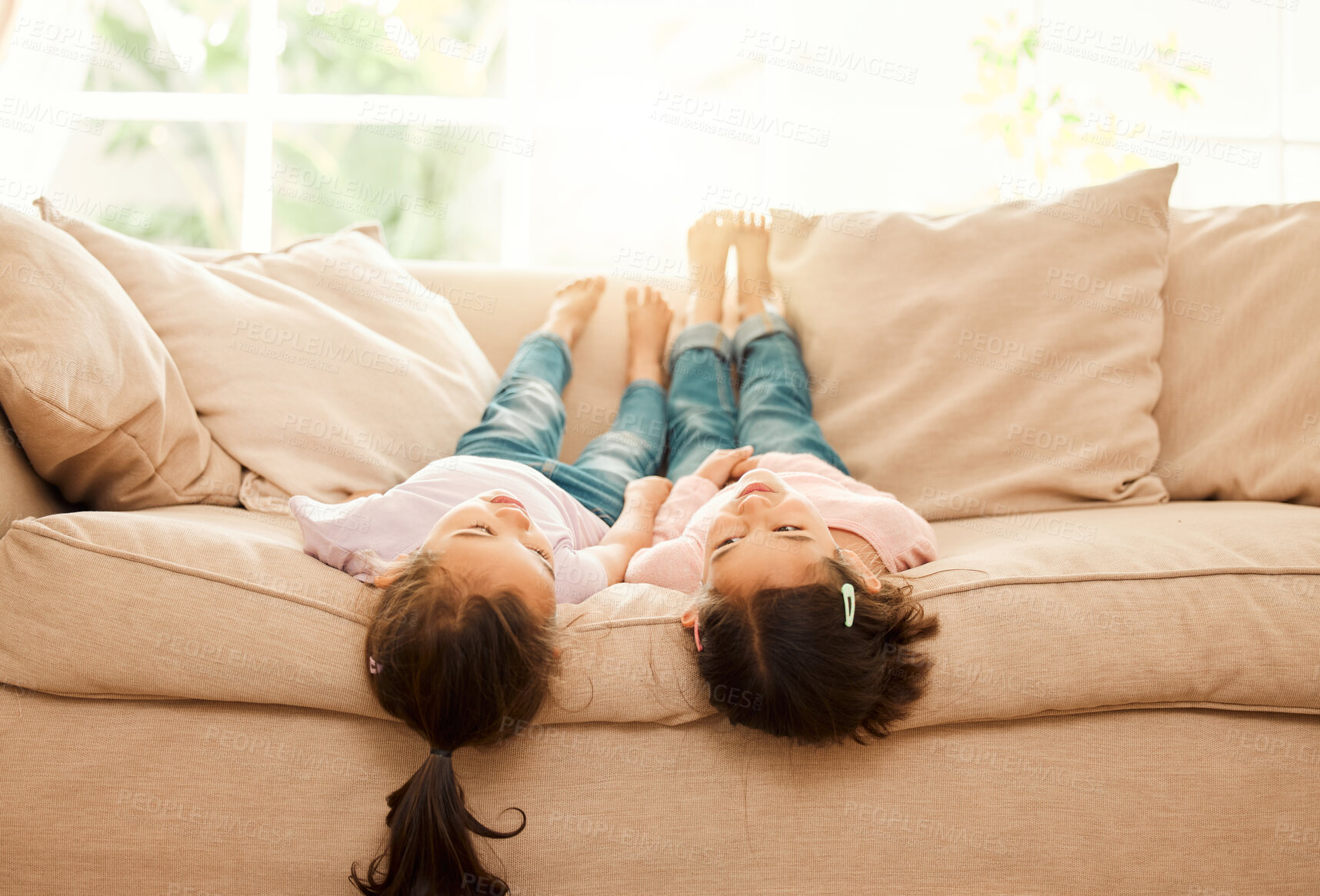 Buy stock photo Shot of two sisters bonding on the couch at home