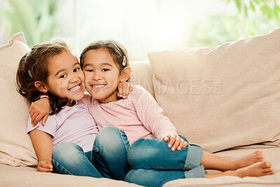 Buy stock photo Shot of two sisters bonding on the couch at home