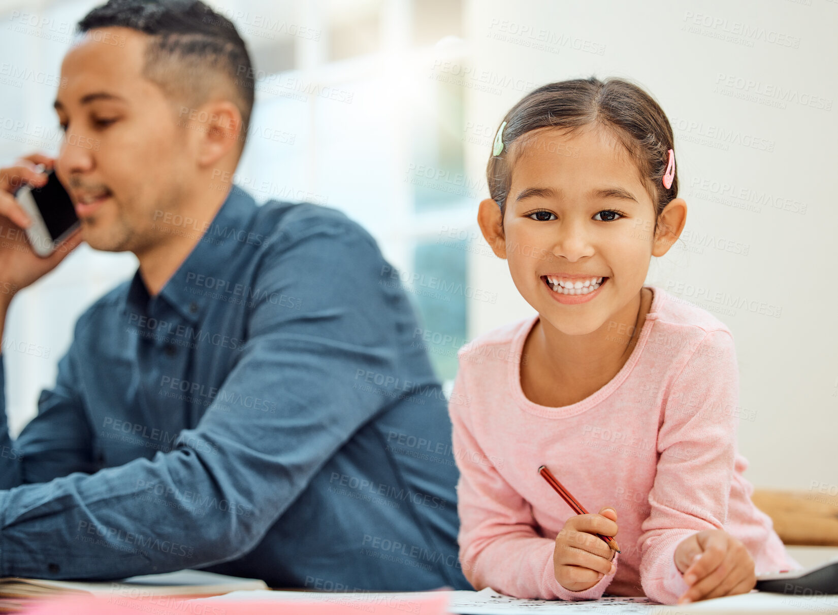 Buy stock photo Cropped portrait of an adorable little girl doing her homework while her dad makes a phonecall in the background