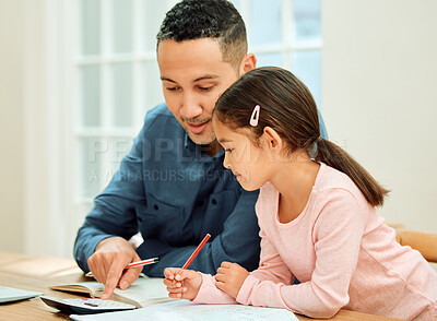 Buy stock photo Cropped shot of an adorable little girl doing her homework with some help from her dad
