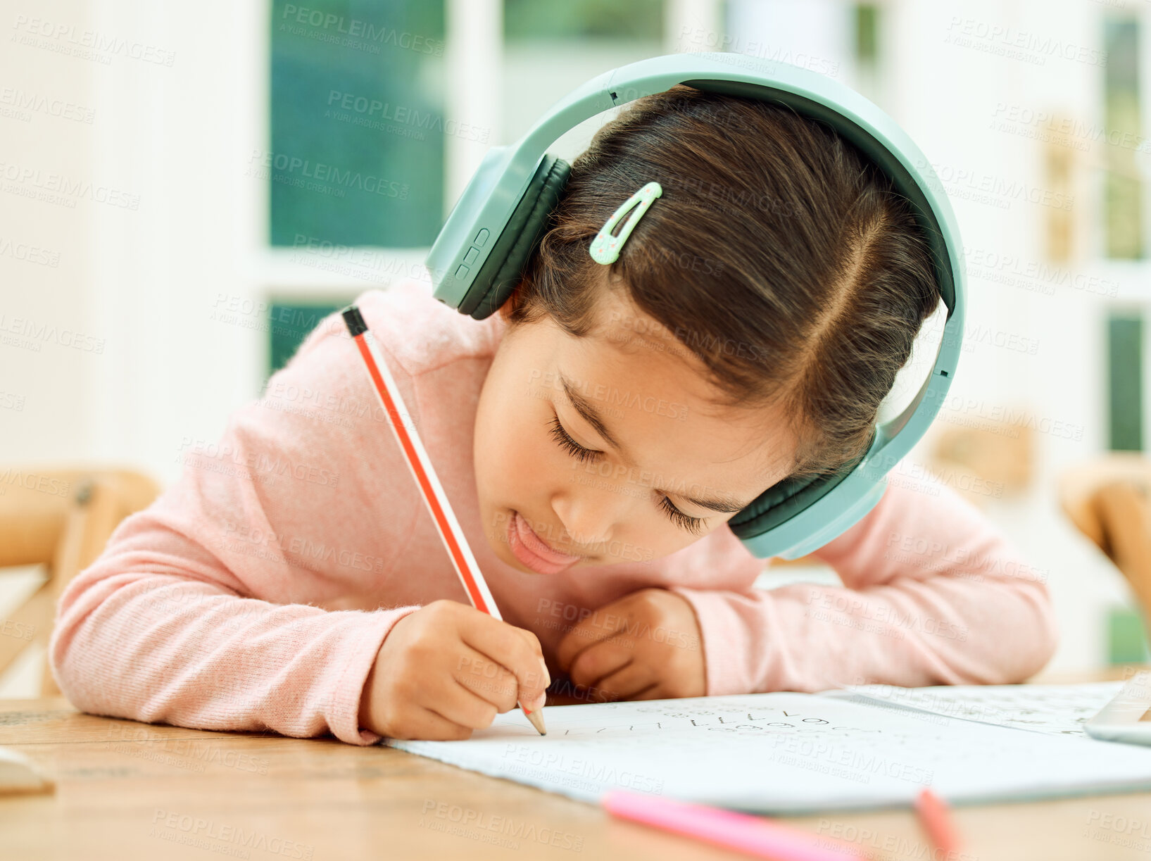 Buy stock photo Home, girl and homework with book for education, learning and practice with math project for kindergarten. Child, studying and cognitive development with writing for learner, knowledge and headphones