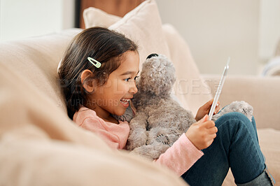 Buy stock photo Kid, girl and happy with tablet on sofa at home on streaming platform for cartoon and movies. Female person, couch and smile or excited in living room with teddy bear on education games for growth