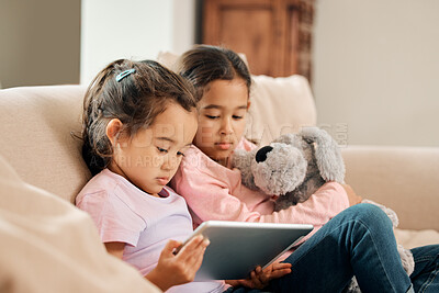 Buy stock photo Children, sisters and serious with tablet on sofa at home on streaming platform for cartoon and movies. Girls, couch and relax in living room with educational games for growth and brain development