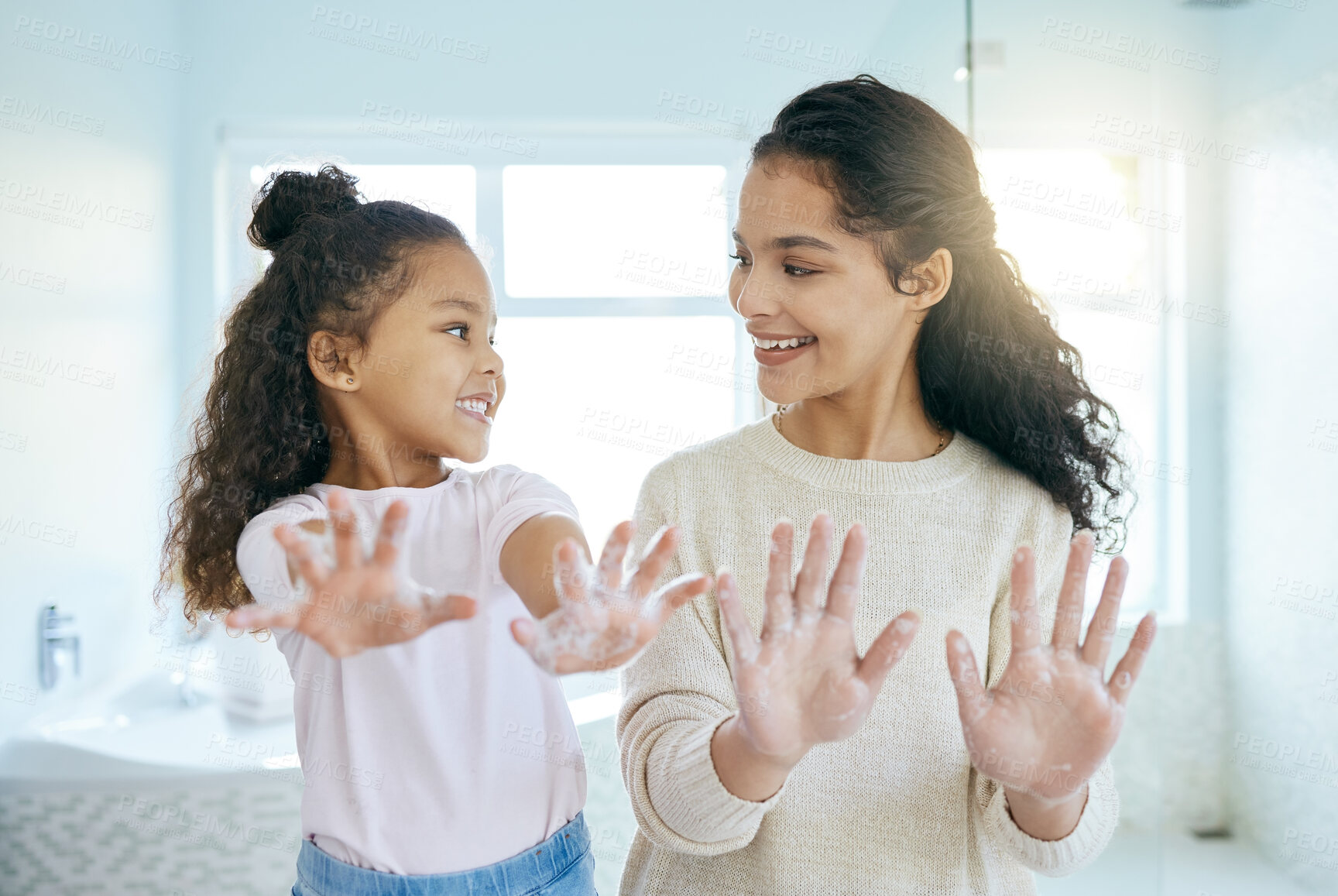 Buy stock photo Soap, cleaning hands and family with kid in bathroom for learning, healthy hygiene and routine at home. Smile, mom and girl washing with foam for safety of bacteria, dirt or germs on skincare