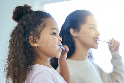 Buy stock photo Mom, girl and brushing teeth in bathroom or house for dental care, oral health and teaching for skill development. Mother, child and together in family home for morning routine, hygiene and wellness.