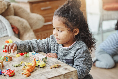 Buy stock photo Shot of an adorable little girl playing with his toys at home