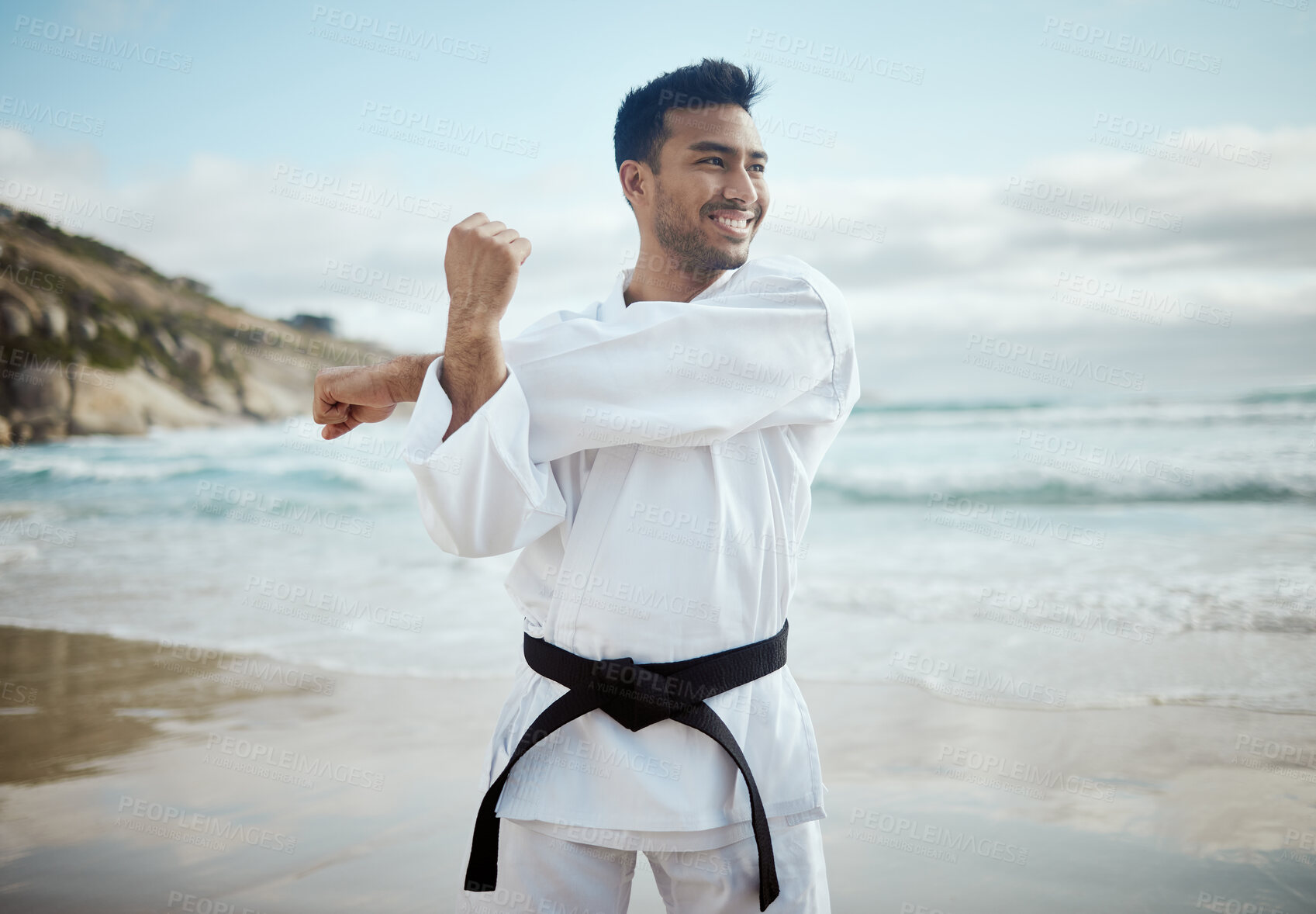 Buy stock photo Beach, karate and man with fitness, stretching and ocean with nature, wellness and balance. Healthy person, seaside and guy with training, smile or practice with professional, martial arts and skills