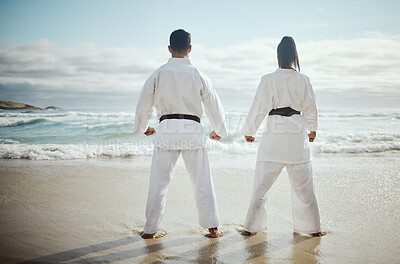 Buy stock photo Rearview shot of two unrecognizable martial artists practicing karate on the beach