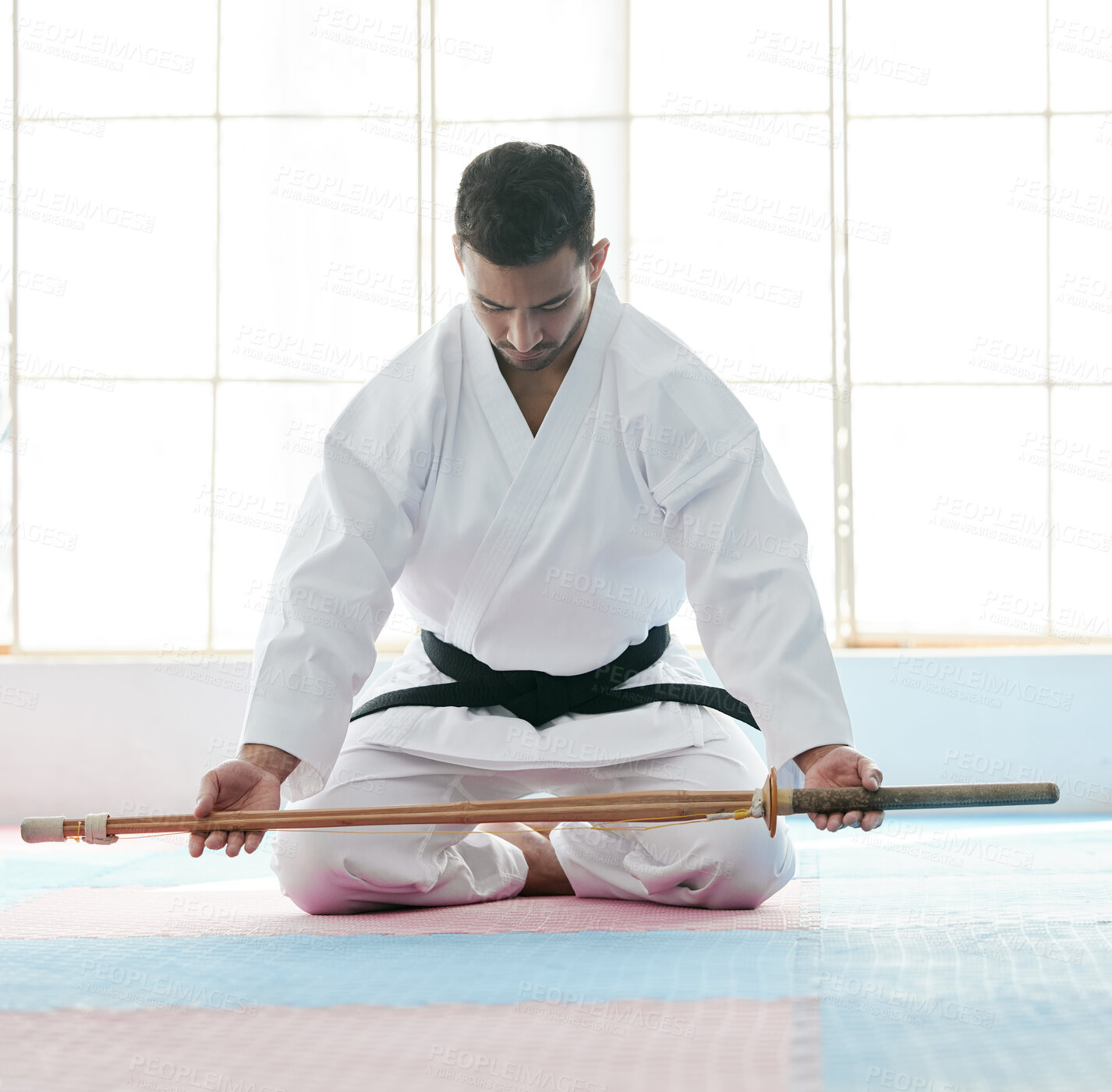 Buy stock photo Bojutsu, karate and man with martial artist, training and discipline with commitment in dojo. Person, studio and guy with weapon, black belt and power with meditation, practice and workout with skill