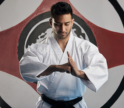 Buy stock photo Discipline, karate and man in dojo, martial artist and sign of respect, greeting and training for competition. Person, sensei and master in uniform, black belt and practice with skills and fitness