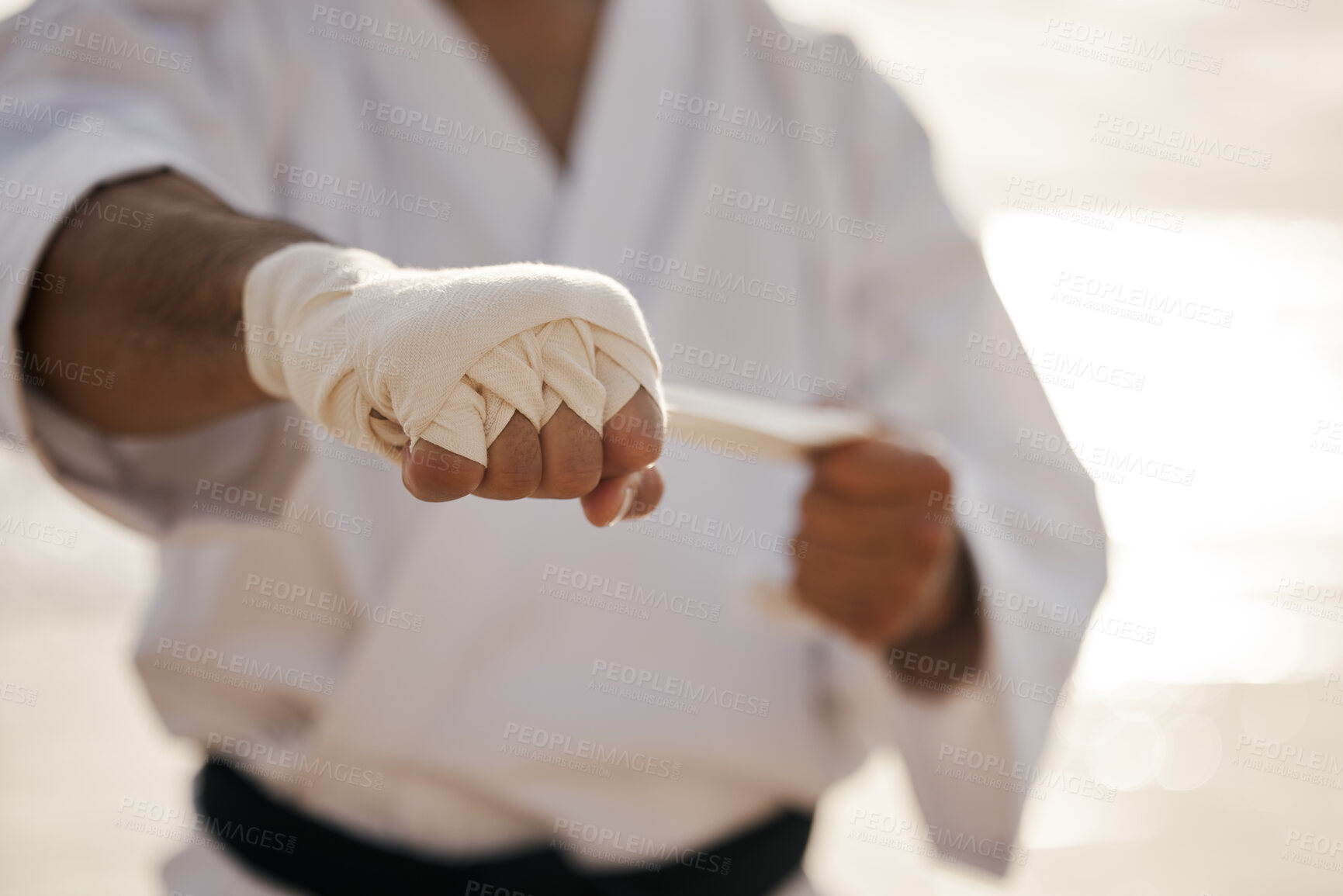 Buy stock photo Hands, fighter and bandage wrapping fist for martial arts, training or exercise to prepare for karate match. Man tying gloves, warrior and getting ready for tournament, practice or beach workout