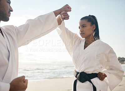 Buy stock photo Cropped shot of two young martial artists practicing karate on the beach