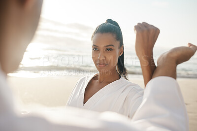 Buy stock photo Cropped shot of two young martial artists practicing karate on the beach