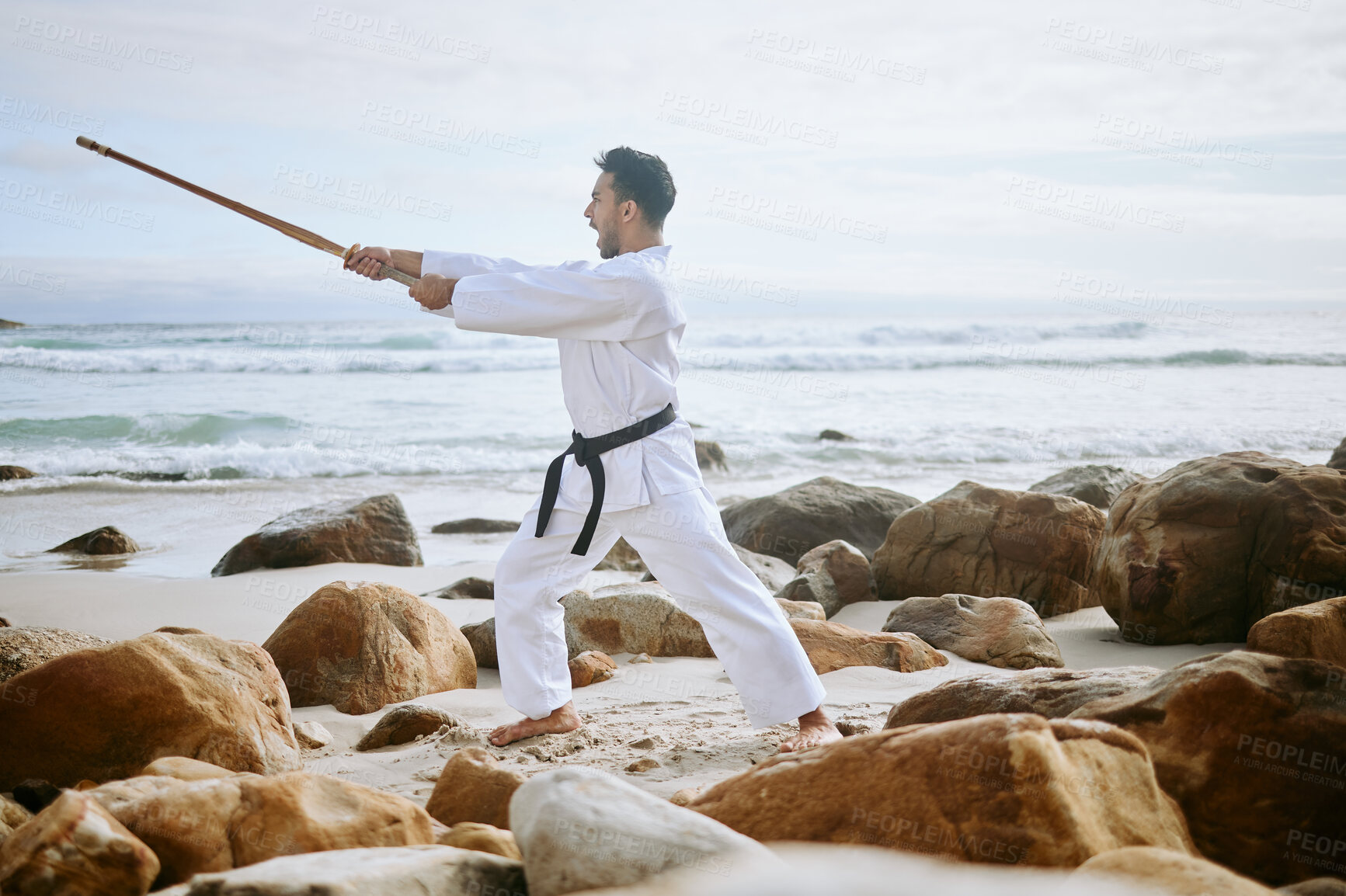 Buy stock photo Karate, beach and man with weapon for training, practice and learning aikido, taekwondo and jiujitsu. Sports, ocean and person with wooden sword for fitness, exercise and workout for martial arts